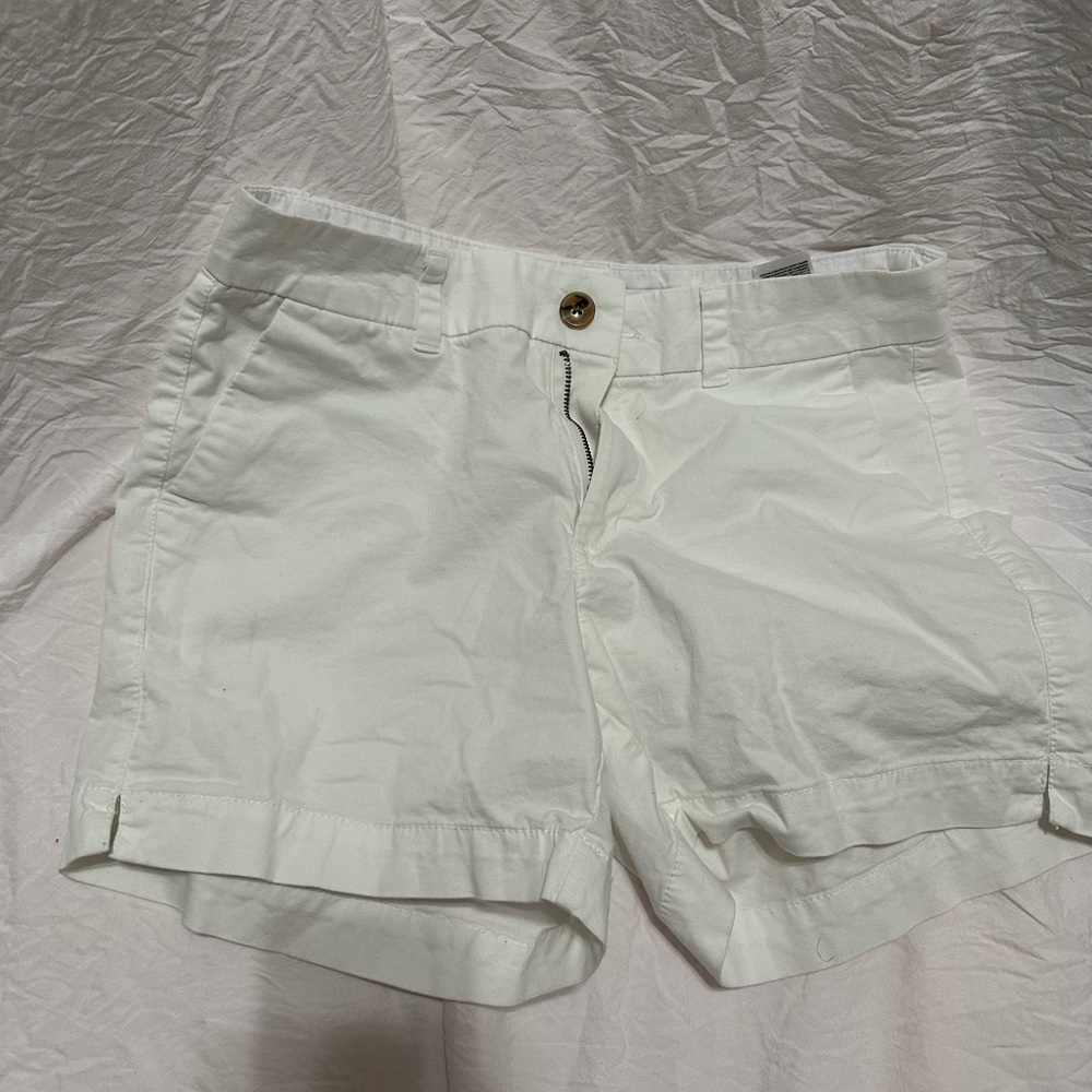 White baby shorts. With a brown and black button with four pockets.